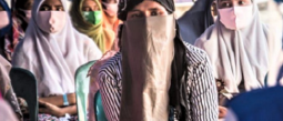 women with face coverings sit in a group